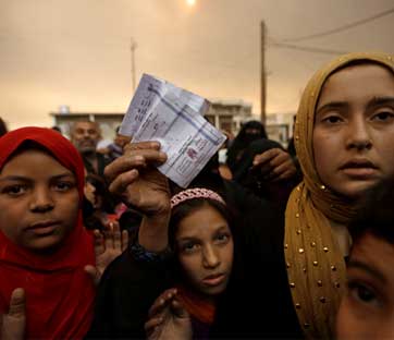 A displaced woman shows her refugee identification paper