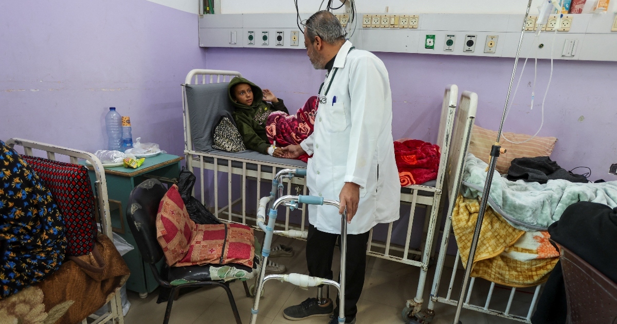 Il medico palestinese Khaled al-Saedni, la cui gamba è stata amputata dopo essere stata ferita in un attacco israeliano, controlla un bambino all'ospedale dei martiri di Al-Aqsa a Deir al-Balah, nella Striscia di Gaza centrale, l'8 gennaio 2025. REUTERS/Ramadan Abed Il medico palestinese Khaled al-Saedni, la cui gamba è stata amputata dopo essere stata ferita in un attacco israeliano, controlla un bambino all'ospedale dei martiri di Al-Aqsa a Deir al-Balah, nella Striscia di Gaza centrale, l'8 gennaio 2025. REUTERS/Ramadan Abed