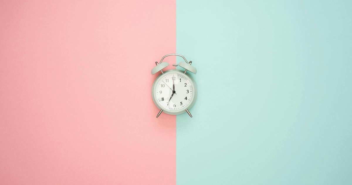 Orologio su uno sfondo azzurro e rosa.
