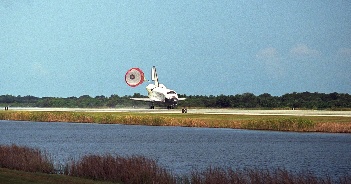 Lo Shuttle in fase di atterraggio con il paracadute dispiegato. Foto: NASA Lo Shuttle in fase di atterraggio con il paracadute dispiegato. Foto: NASA