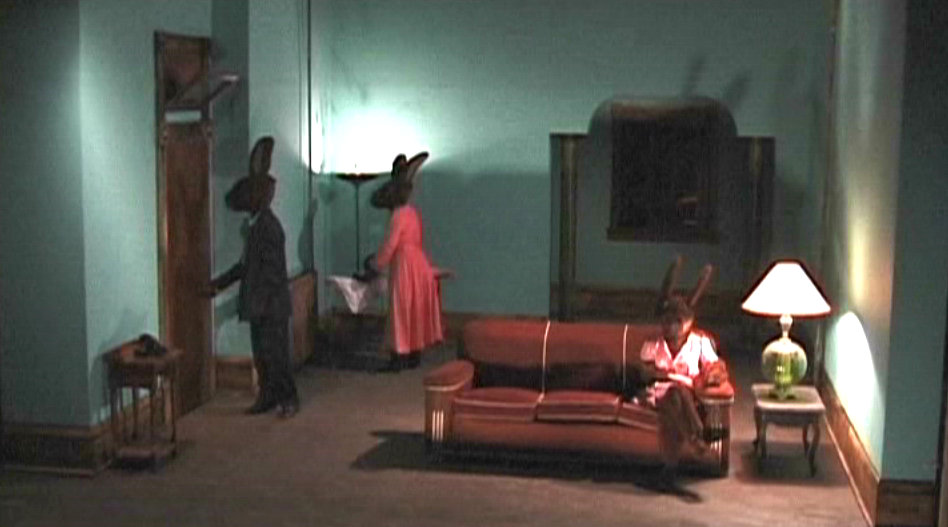 salotto con conigli umani -scena di un film di lynch