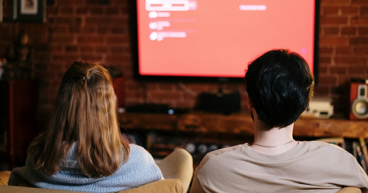 coppia sul divano che guarda la tv