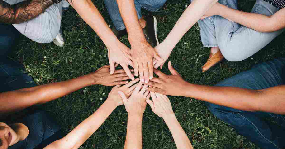 mani una sopra l'altra con braccia a stella