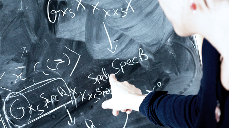 mano femminile indicante calcoli matematici su lavagna 