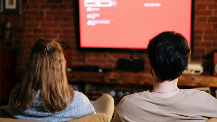 coppia sul divano che guarda la tv