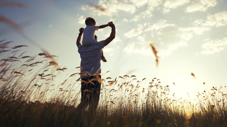 Un figlio sulle spalle di un padre